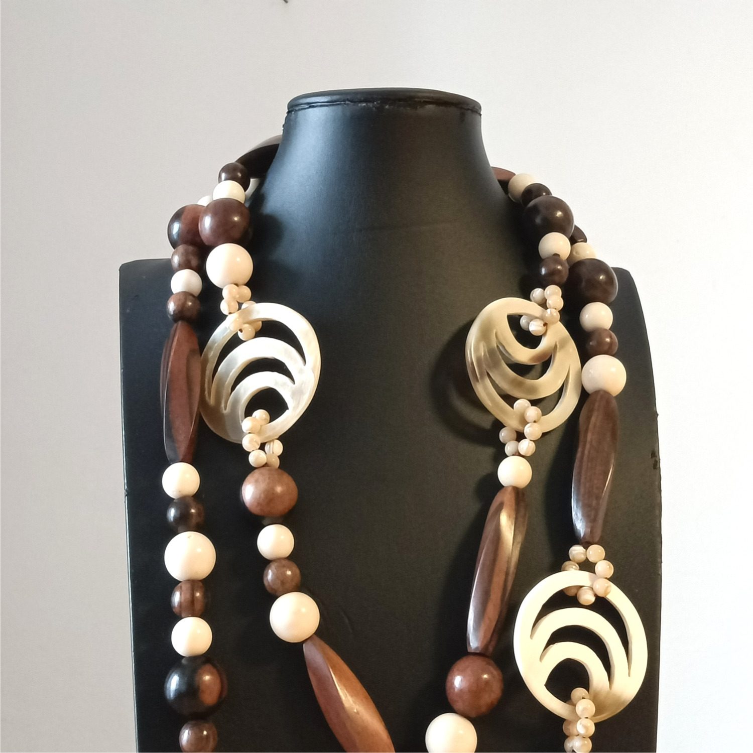 Dettaglio collana Mezzelune con elementi circolari in corno naturale, perline ed elementi in legno marrone